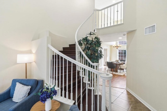 stairs featuring tile patterned flooring and a towering ceiling