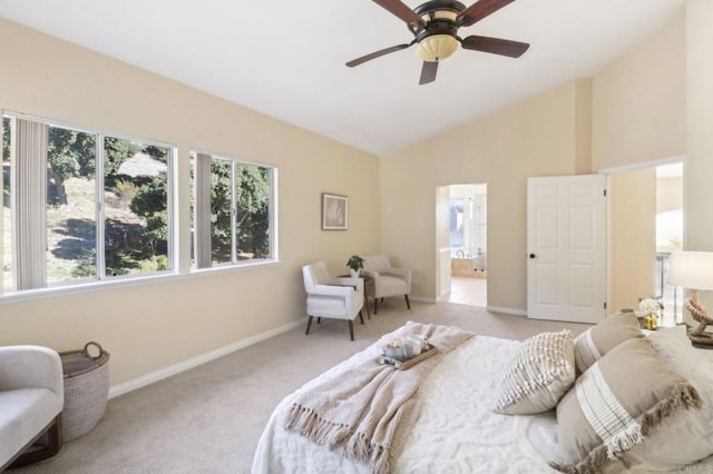 carpeted bedroom with ensuite bath, ceiling fan, and high vaulted ceiling