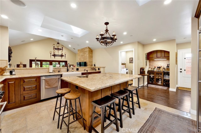 kitchen with pendant lighting, a large island, a breakfast bar, and stainless steel dishwasher