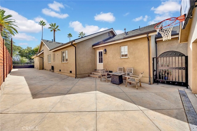 rear view of property featuring a patio area and a fire pit