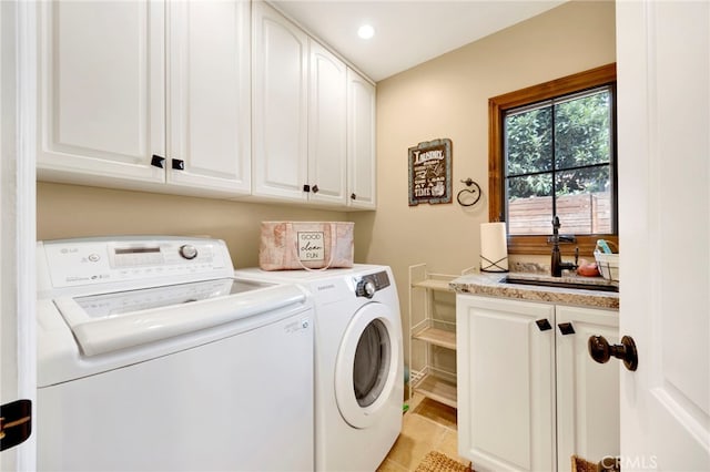 washroom featuring washer and dryer, cabinets, light tile patterned floors, and sink