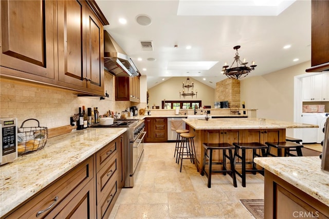 kitchen featuring light stone countertops, a breakfast bar, stainless steel appliances, extractor fan, and a kitchen island