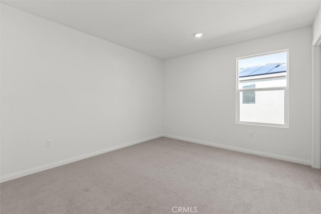 empty room with baseboards and light colored carpet