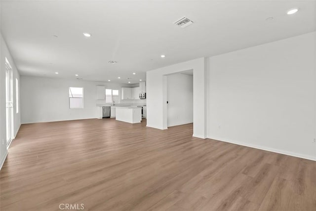 unfurnished living room with light wood finished floors, visible vents, and recessed lighting