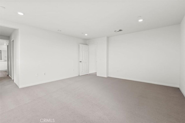 unfurnished room featuring recessed lighting, visible vents, light carpet, and baseboards