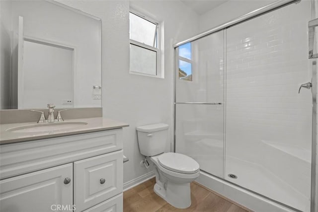 bathroom with vanity, toilet, hardwood / wood-style floors, and walk in shower