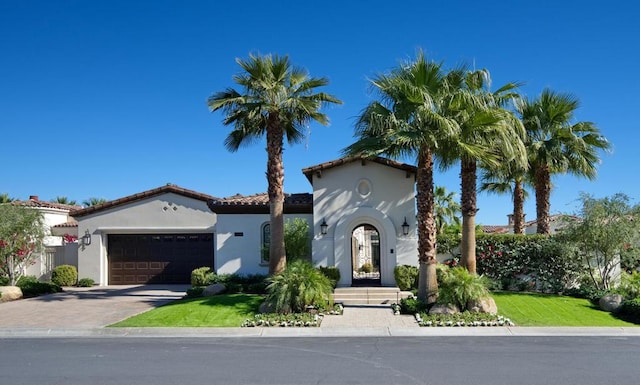 mediterranean / spanish-style home with a front yard and a garage