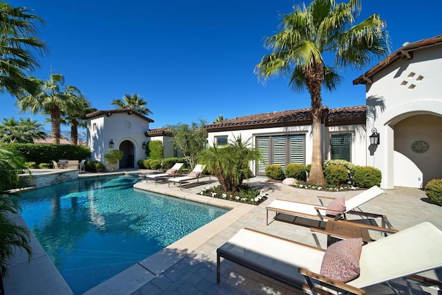 view of pool featuring a patio and exterior fireplace