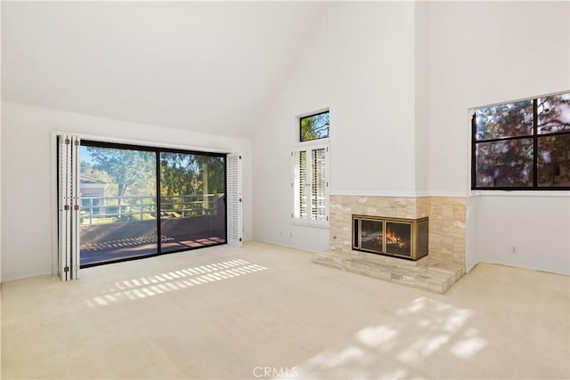 unfurnished living room with carpet, a fireplace, and high vaulted ceiling