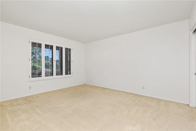 unfurnished room featuring light colored carpet