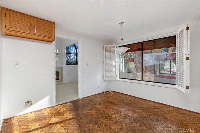 unfurnished dining area with a wealth of natural light and dark parquet floors