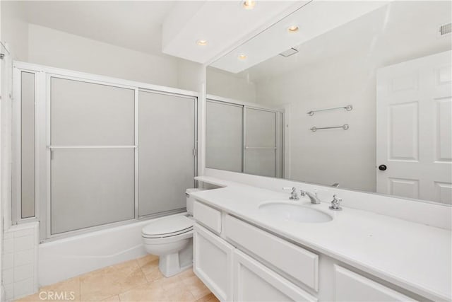 full bathroom featuring tile patterned floors, vanity, toilet, and bath / shower combo with glass door