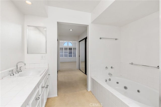 bathroom featuring vanity and a relaxing tiled tub