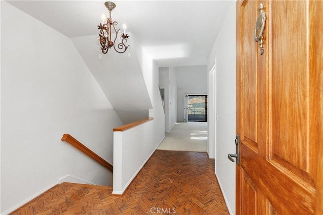 hall featuring parquet flooring and a chandelier