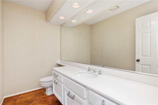 bathroom featuring vanity, parquet floors, and toilet