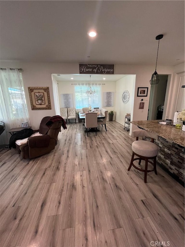 dining space with light hardwood / wood-style flooring and a notable chandelier