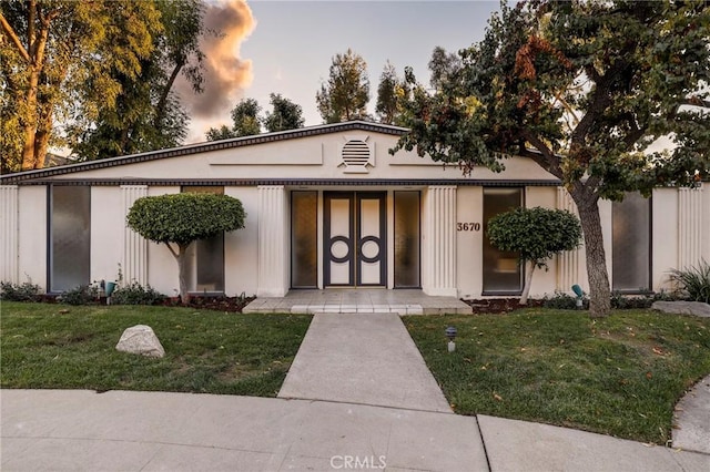 exterior entry at dusk with a yard