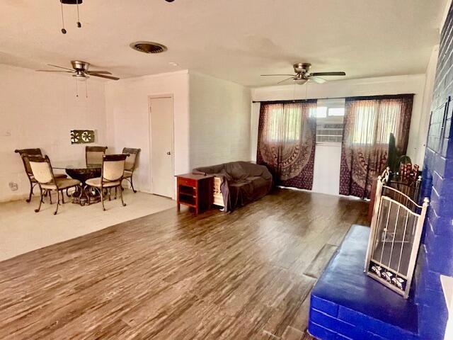 living room with ceiling fan and wood-type flooring