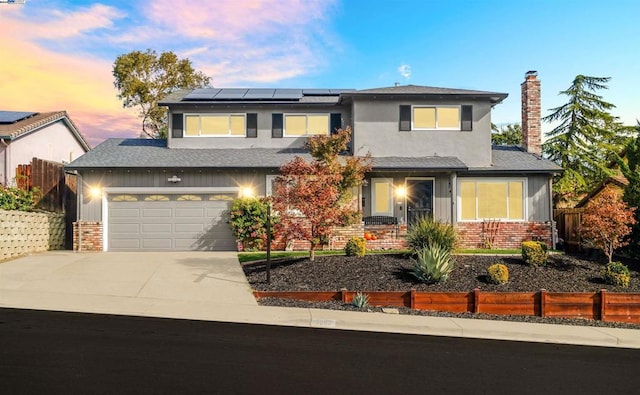 view of front of property with solar panels and a garage