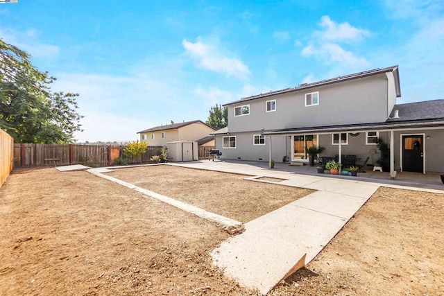 back of house with a patio area and a storage unit