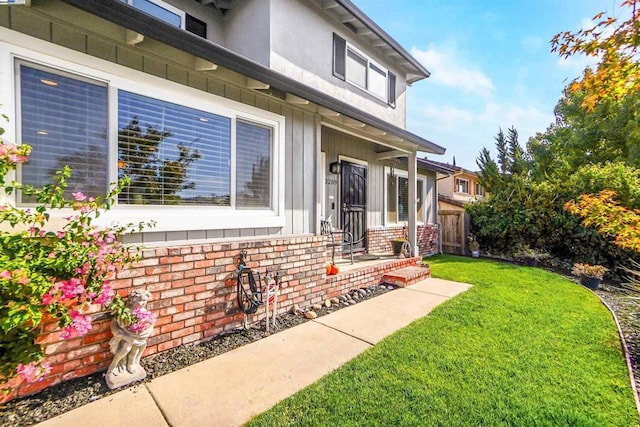 view of exterior entry with a lawn