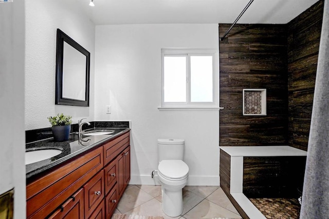 bathroom with tile patterned floors, vanity, toilet, and a tile shower