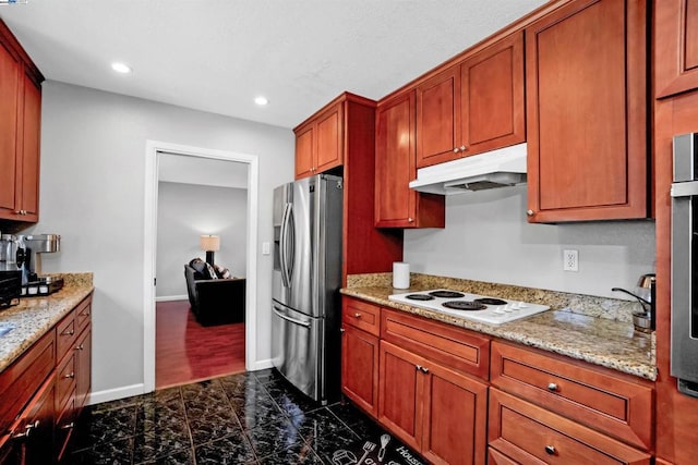 kitchen featuring stainless steel fridge, light stone counters, and white electric stovetop