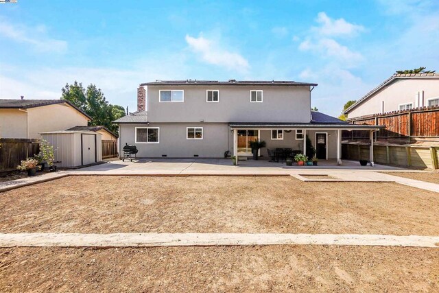 rear view of house featuring a shed and a patio