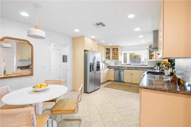 kitchen with appliances with stainless steel finishes, sink, pendant lighting, dark stone countertops, and light tile patterned flooring