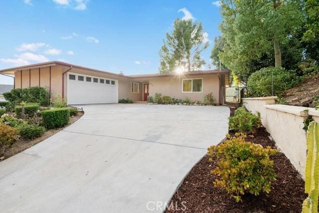 ranch-style home featuring a garage and driveway