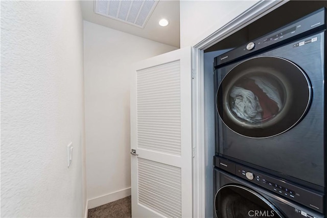 washroom featuring stacked washer and clothes dryer