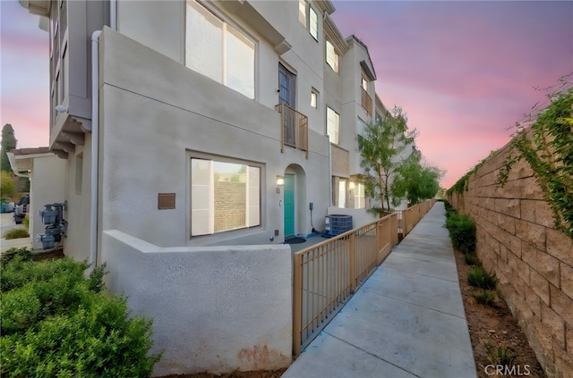 property exterior at dusk featuring central AC unit