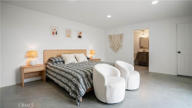 bedroom with ensuite bathroom and concrete flooring