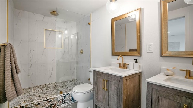 bathroom featuring tiled shower, vanity, and toilet