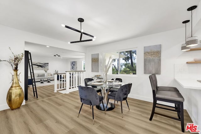 dining room with light hardwood / wood-style flooring and a notable chandelier