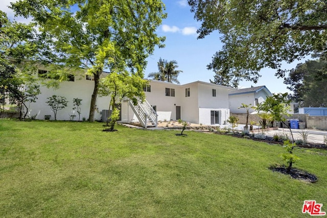 exterior space featuring cooling unit and a lawn