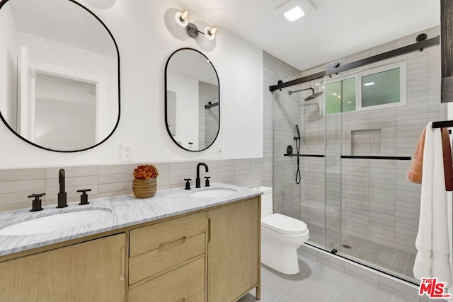 bathroom featuring toilet, vanity, tile walls, and walk in shower