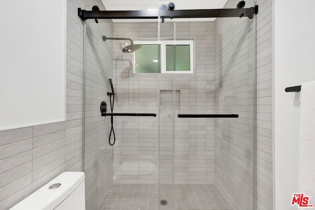 bathroom featuring an enclosed shower, toilet, and tile walls