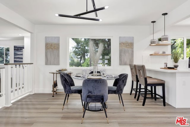 dining space featuring light wood-type flooring and plenty of natural light