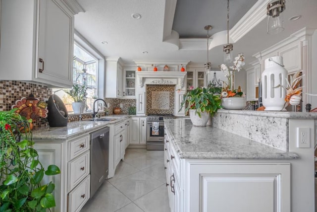 kitchen with tasteful backsplash, stainless steel appliances, hanging light fixtures, and white cabinets