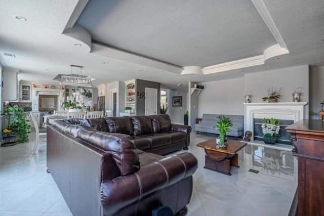 living room featuring ornamental molding, a raised ceiling, and a textured ceiling