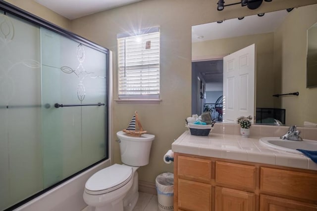 full bathroom with vanity, enclosed tub / shower combo, and toilet