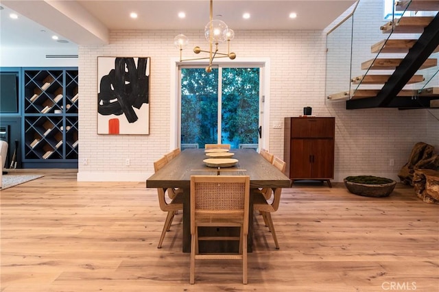 dining room featuring light hardwood / wood-style floors and brick wall