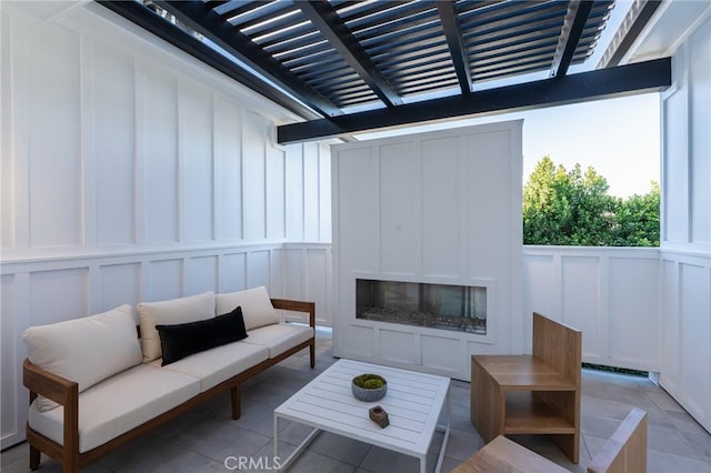 view of patio with an outdoor living space with a fireplace and a pergola