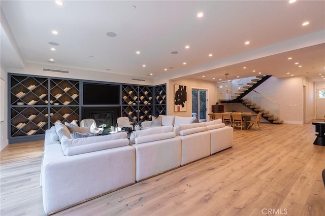 living area featuring visible vents, stairway, recessed lighting, and light wood finished floors