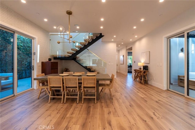 dining space featuring light hardwood / wood-style floors and an inviting chandelier