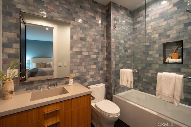 full bath featuring vanity, enclosed tub / shower combo, ensuite bath, toilet, and tile walls