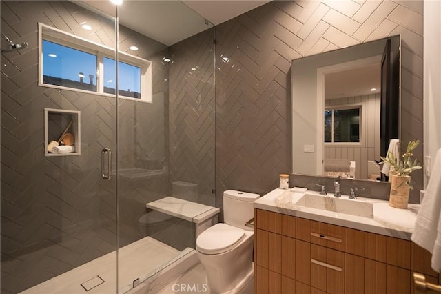 bathroom with toilet, a stall shower, and vanity