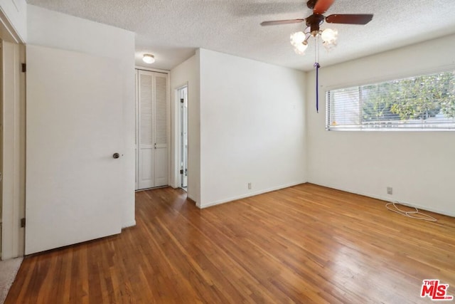 unfurnished room featuring ceiling fan, wood-type flooring, and a textured ceiling