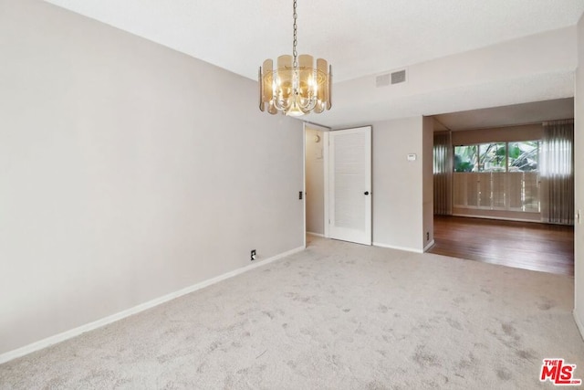 unfurnished room featuring hardwood / wood-style flooring and a chandelier